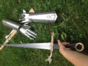 The blade, cross-guard, and pommel in their positions, along with her sheath and gauntlets (made with friend at Madison East metal shop) in the background