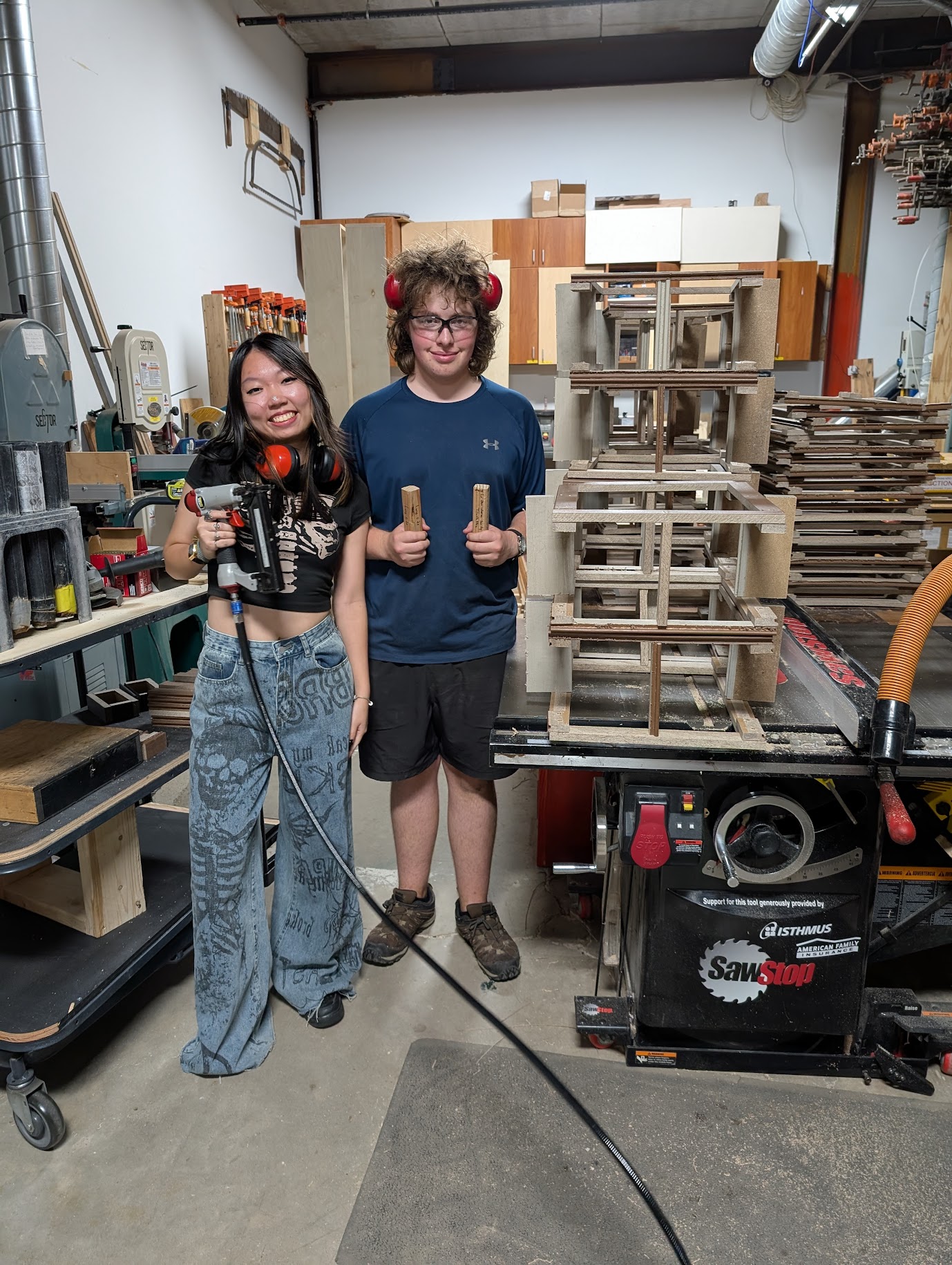 2025 interns Vivian (left) and Cooper (right) with a stack of carrot seed planters
